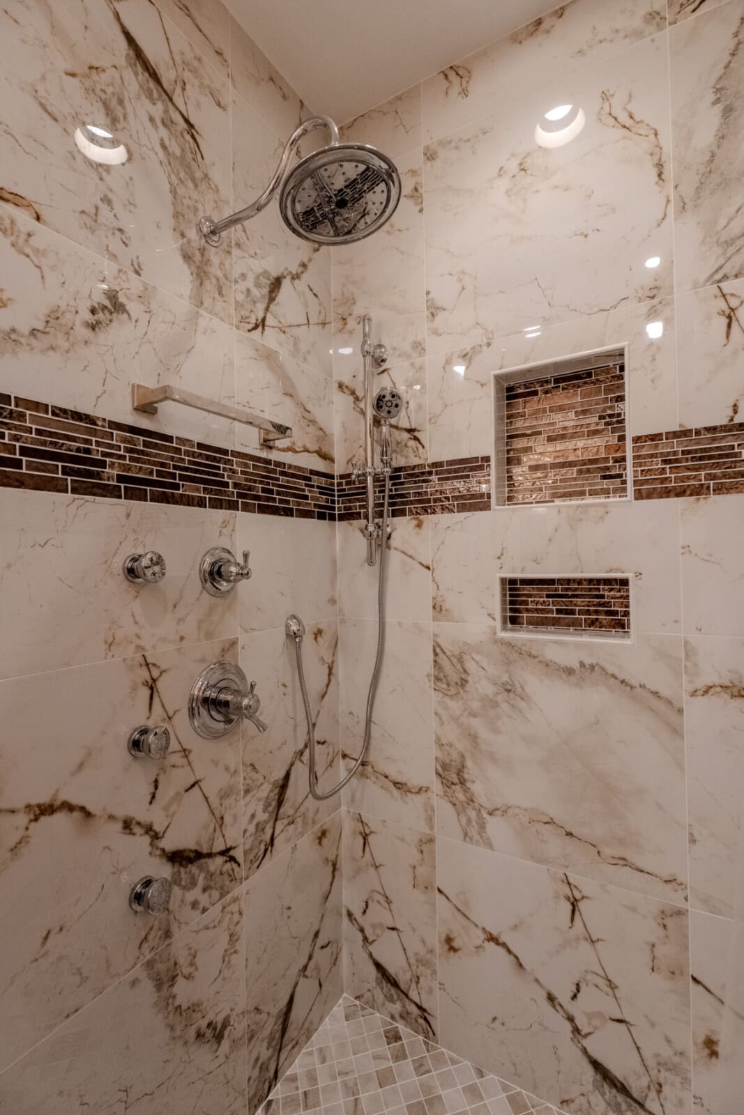 This en suite bathroom with zero-entry shower, rainfall shower, hand-held shower, and body jets flows seamlessly from a private bedroom retreat for comfort, ease, and a touch of everyday luxury.