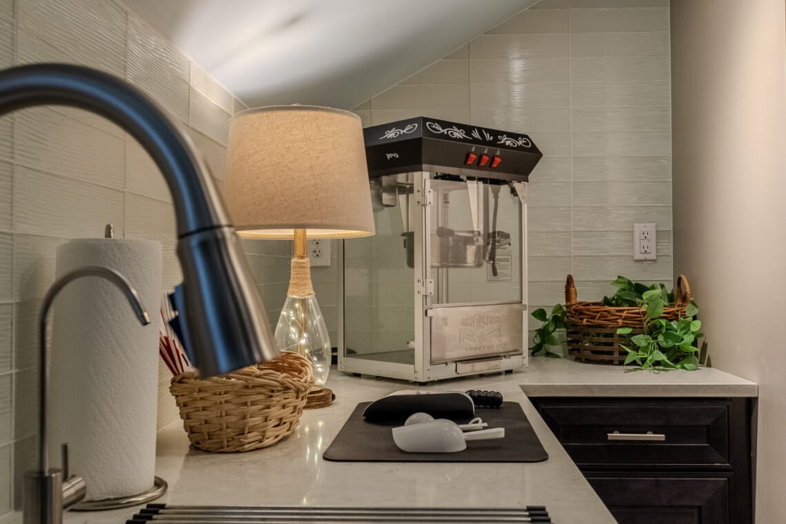 The concessions area—with popcorn, filtered water, and a mini-fridge—keeps refreshments close at hand for movie nights, game days, and group fun.