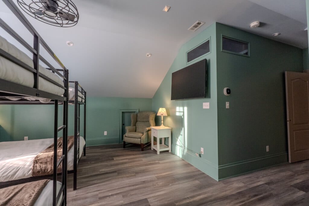 This view of the queen bunk room highlights generous sleeping and circulation space designed for families, friends, and group stays.