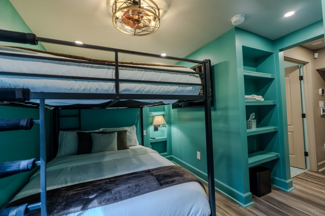 Thoughtful queen bunk room details, including lighting designed separately for each bunk, help make group stays feel comfortable, welcoming, and well planned.