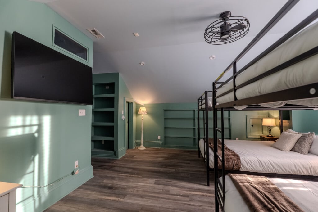 Another angle of the queen bunk room shows flexible sleeping space designed for guests to rest, reconnect, and feel at home.